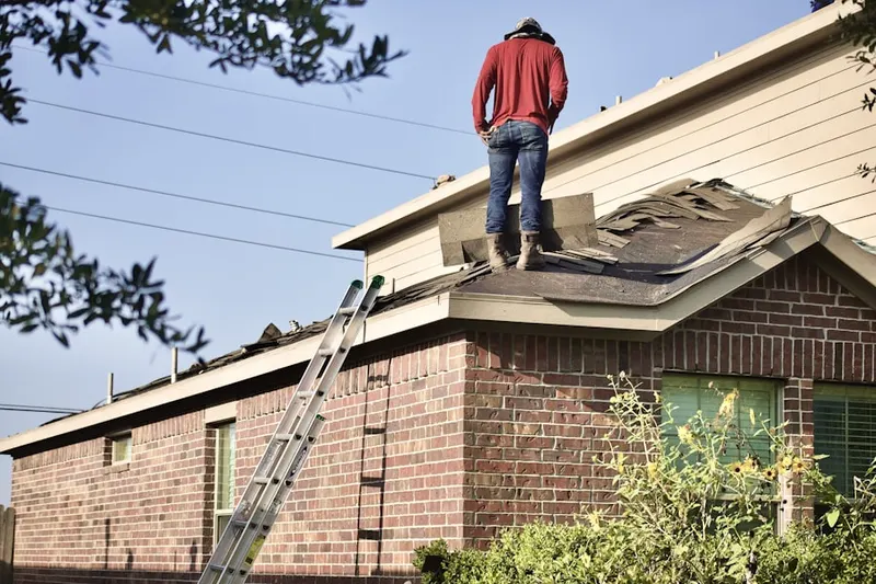 Professional roofer working on a residential roof in Mowry